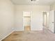 Spacious bedroom with neutral carpet, white trim, open closet and adjoining hallway at 2880 E Nunneley Rd, Gilbert, AZ 85296
