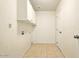 A bright laundry room with tile floors and functional cabinet space above washer and dryer hookups at 2880 E Nunneley Rd, Gilbert, AZ 85296
