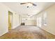 Expansive living room with plush carpeting, ceiling fans, fireplace, and a view of the adjacent kitchen at 2880 E Nunneley Rd, Gilbert, AZ 85296