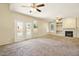 Bright living room with fireplace, ceiling fans, and french doors leading to outdoor area at 2880 E Nunneley Rd, Gilbert, AZ 85296