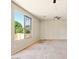 An open carpeted living room is naturally lit through a window overlooking the green outdoors at 2880 E Nunneley Rd, Gilbert, AZ 85296