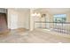 Bright living room featuring vaulted ceilings, a railing to upstairs, and neutral carpet at 2880 E Nunneley Rd, Gilbert, AZ 85296