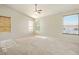 Large carpeted primary bedroom with multiple windows and a ceiling fan at 2880 E Nunneley Rd, Gilbert, AZ 85296