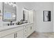 Modern bathroom with a double vanity, white cabinets, stylish mirrors, and elegant fixtures at 300 S Charleston Ct, Casa Grande, AZ 85194