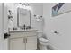 Charming powder room with a white vanity, black hardware, decorative mirror and modern lighting at 300 S Charleston Ct, Casa Grande, AZ 85194
