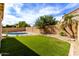 Landscaped backyard featuring a pool, green grass, and desert landscaping at 3132 E Wildwood Dr, Phoenix, AZ 85048