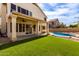 Home's backyard featuring covered patio, pool, artificial turf, and desert landscape at 3132 E Wildwood Dr, Phoenix, AZ 85048