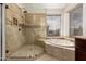 A bathroom showcasing a walk-in shower and a garden tub by a window with a view of the scenery at 3132 E Wildwood Dr, Phoenix, AZ 85048