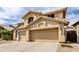 View of the home with an attached three-car garage, large driveway, and desert landscaping at 3132 E Wildwood Dr, Phoenix, AZ 85048