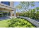 Lush backyard featuring synthetic grass, a covered patio, and meticulously maintained landscaping at 3310 E Los Gatos Dr, Phoenix, AZ 85050