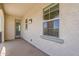 Stucco balcony featuring exterior lighting and windows, with a glass door entrance offering seamless indoor-outdoor living at 3310 E Los Gatos Dr, Phoenix, AZ 85050
