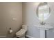 This bathroom features a modern pedestal sink and toilet with designer fixtures and bright lighting at 3310 E Los Gatos Dr, Phoenix, AZ 85050