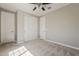 Bright bedroom with ample closet space, featuring a ceiling fan, neutral paint, and carpet flooring at 3310 E Los Gatos Dr, Phoenix, AZ 85050