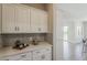 Butler's pantry offers ample storage with white cabinets and elegant subway tile backsplash at 3310 E Los Gatos Dr, Phoenix, AZ 85050