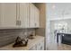 Butler's pantry features white cabinets, sleek hardware, and gray tile backsplash at 3310 E Los Gatos Dr, Phoenix, AZ 85050