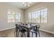 Bright dining room features wood floors, a modern chandelier, and big windows for plenty of natural light at 3310 E Los Gatos Dr, Phoenix, AZ 85050