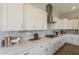 Gourmet kitchen featuring white cabinets, gray backsplash, modern stainless hood, and quartz countertops at 3310 E Los Gatos Dr, Phoenix, AZ 85050