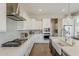 Close view of kitchen with stainless appliances, white cabinets, gas cooktop, and stylish backsplash at 3310 E Los Gatos Dr, Phoenix, AZ 85050