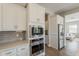 Gourmet kitchen with stainless steel appliances, white cabinets, and gray subway tile backsplash at 3310 E Los Gatos Dr, Phoenix, AZ 85050