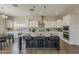 Kitchen featuring large island with seating, stainless appliances, white cabinets, and wood-look floors at 3310 E Los Gatos Dr, Phoenix, AZ 85050
