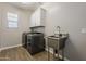 Efficient laundry room with modern washer/dryer, utility sink, wood-look tile, and storage cabinets for organized convenience at 3310 E Los Gatos Dr, Phoenix, AZ 85050