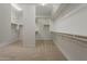 Well-lit walk-in closet with carpet and organized shelving, offering plenty of room for clothing and accessories at 3310 E Los Gatos Dr, Phoenix, AZ 85050