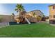 Playful backyard with a custom playset, artificial turf, and mature trees, offering a fun space for  at 3715 W Teresa Dr, New River, AZ 85087