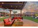 Backyard patio features comfortable seating around a fire pit, all under a pergola at 3715 W Teresa Dr, New River, AZ 85087