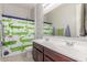 Well lit bathroom with double sinks, tile floors, and a colorful crocodile-themed shower curtain at 3715 W Teresa Dr, New River, AZ 85087