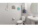 Coastal-themed half bath featuring a pedestal sink, toilet, and decorative nautical accents at 3715 W Teresa Dr, New River, AZ 85087