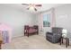 Bedroom with a crib, rocking chair, neutral carpet, and soft pink accents at 3715 W Teresa Dr, New River, AZ 85087