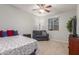 A bedroom features a ceiling fan, a grey couch, and colorful bedding at 3715 W Teresa Dr, New River, AZ 85087