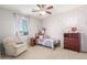 A bedroom showcases a patterned accent wall, a ceiling fan, and pink curtains at 3715 W Teresa Dr, New River, AZ 85087