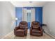 A bonus room showcases recliners, neutral paint, and a blue accent wall at 3715 W Teresa Dr, New River, AZ 85087