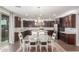 A dining room showcasing dark kitchen cabinetry, stainless appliances, and a dining table for six guests at 3715 W Teresa Dr, New River, AZ 85087