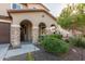 Charming covered front porch featuring stone columns, lush greenery, and desert landscaping at 3715 W Teresa Dr, New River, AZ 85087