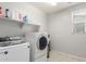 Well-lit laundry room featuring tile flooring, washer, dryer, and ample shelving space at 3715 W Teresa Dr, New River, AZ 85087