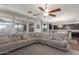 Open-concept living room featuring a large sectional sofa, ceiling fan, and a view into the kitchen at 3715 W Teresa Dr, New River, AZ 85087