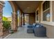 Relaxing covered patio with stone pillars, comfortable seating, and views of the lush backyard at 3715 W Teresa Dr, New River, AZ 85087
