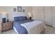Comfortable bedroom with tiled floors, neutral walls, and a cozy blue quilted bedspread with white throw at 3755 N 151St Ave, Goodyear, AZ 85395