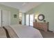 Bedroom with light green walls, vaulted ceiling, dresser, and patio access at 3755 N 151St Ave, Goodyear, AZ 85395