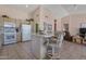 Bright eat-in kitchen features an island with seating, tile floors, and neutral color palette at 3755 N 151St Ave, Goodyear, AZ 85395