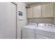 Neat laundry room with a side-by-side washer and dryer and built-in storage cabinets at 3755 N 151St Ave, Goodyear, AZ 85395