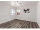 Bedroom with vinyl plank flooring and windows with neighborhood views, ceiling fan, and artwork at 39 N Maple St, Mesa, AZ 85205