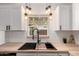 Close up of kitchen sink with modern matte black faucet, butcher block countertops, and subway tile backsplash at 39 N Maple St, Mesa, AZ 85205