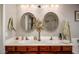 Bathroom featuring double sinks, oval mirrors, stylish vanity, and modern fixtures at 4083 E Rustler Way, Gilbert, AZ 85297