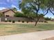 Well-manicured community landscape with a low wall, manicured bushes and mature shade trees enhancing curb appeal at 4083 E Rustler Way, Gilbert, AZ 85297