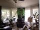 Relaxing living room featuring comfortable leather furniture, sheer curtains, and indoor plants creating a tranquil ambiance at 4083 E Rustler Way, Gilbert, AZ 85297