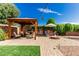 Inviting backyard patio featuring a gazebo, fire pit, and lush greenery under a bright blue sky at 410 E Beck Ln, Phoenix, AZ 85022