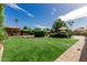 Spacious backyard featuring lush green grass, mature trees, and a cozy gazebo with seating for outdoor gatherings at 410 E Beck Ln, Phoenix, AZ 85022